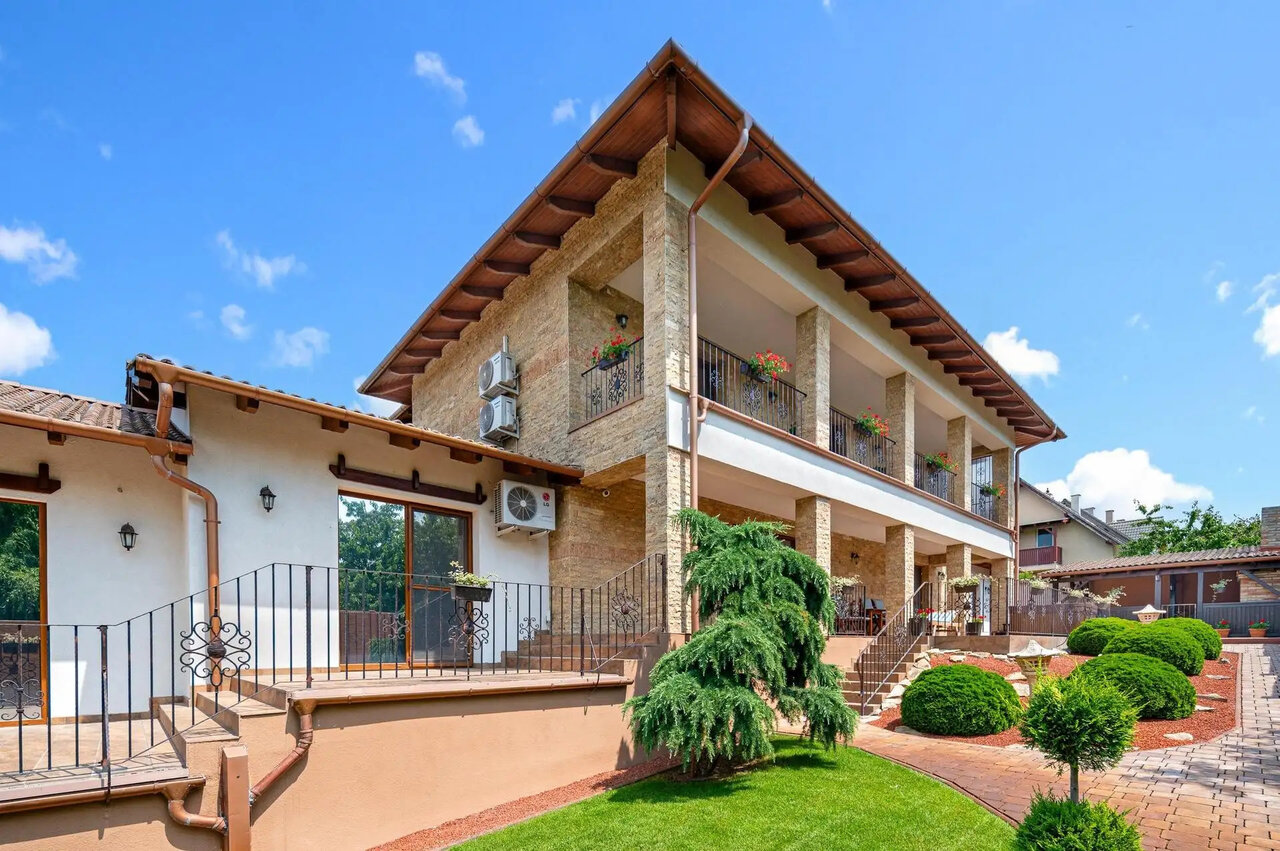 Mediterranean family house facade with manicured garden and balconies