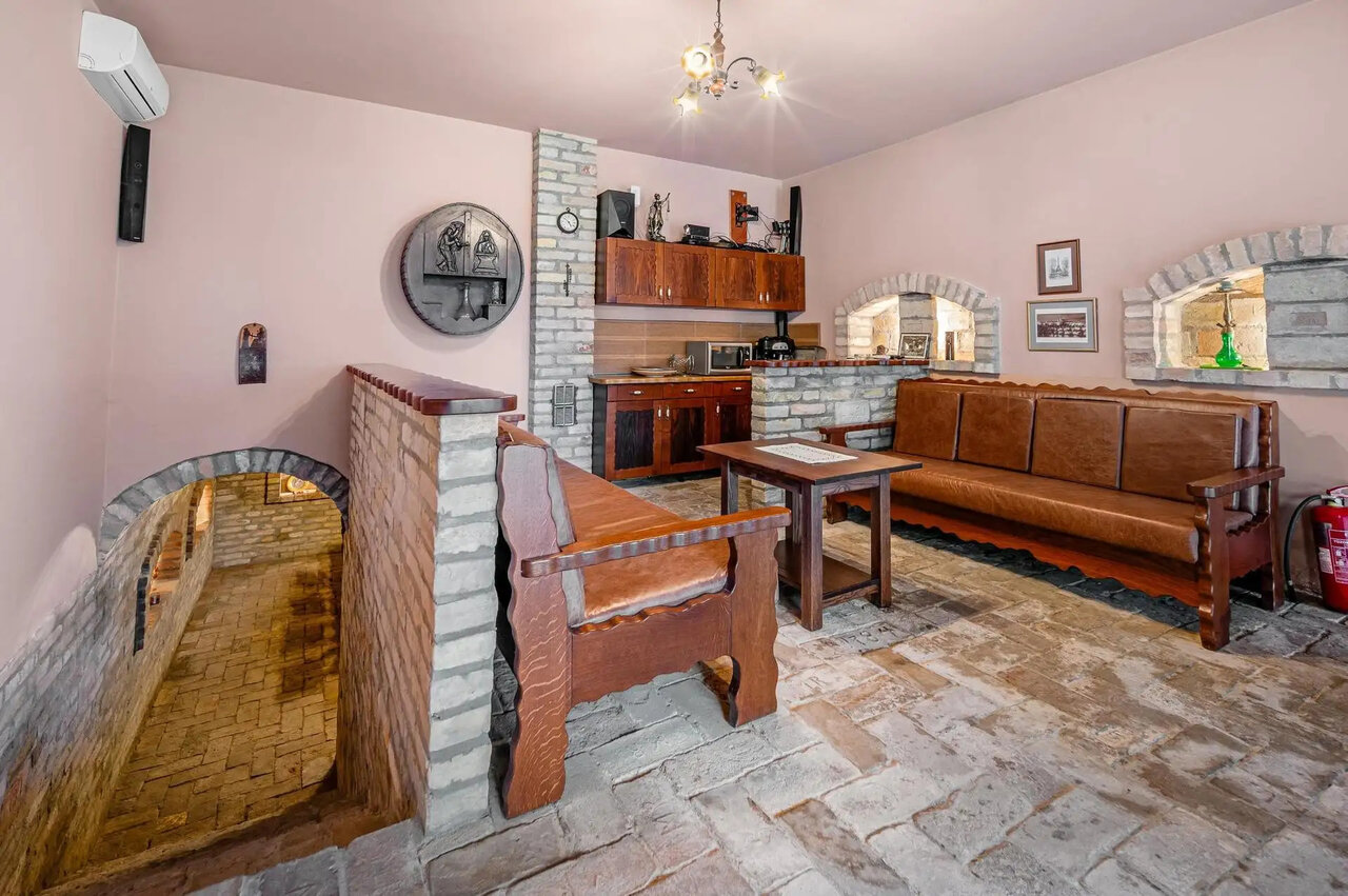 Rustic living area with brick cladding and wine cellar entrance
