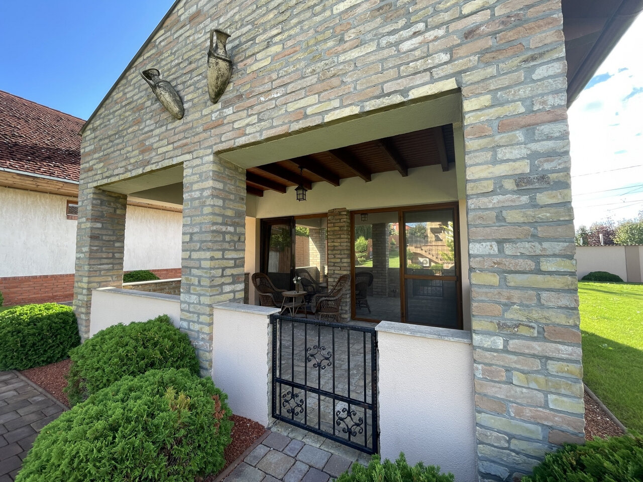 Covered terrace with garden furniture and garden access